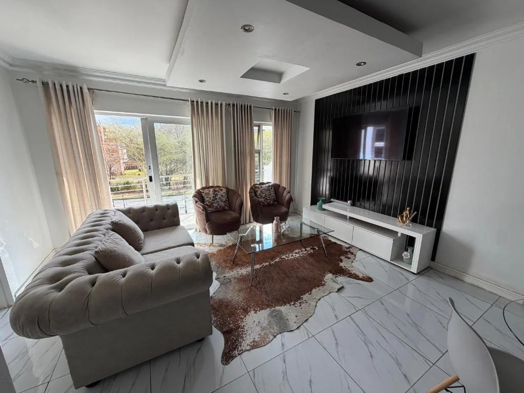 Elegant living room with comfortable sofas and a balcony